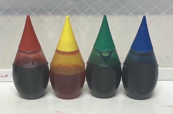 Bottles of red, yellow, green and blue artificial food colouring