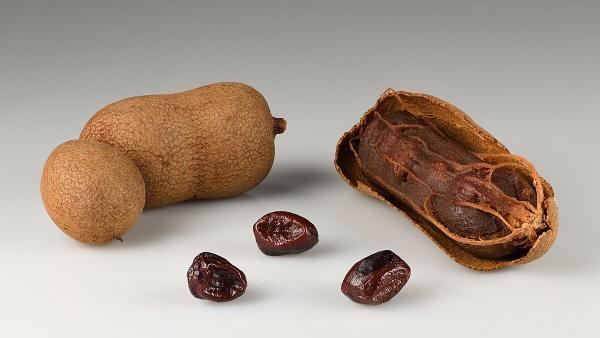 Thai sweet tamarind pods, whole and cracked open, with seeds