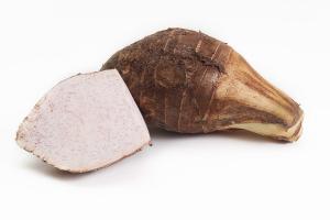 A taro corm cut open to show its purple-flecked flesh